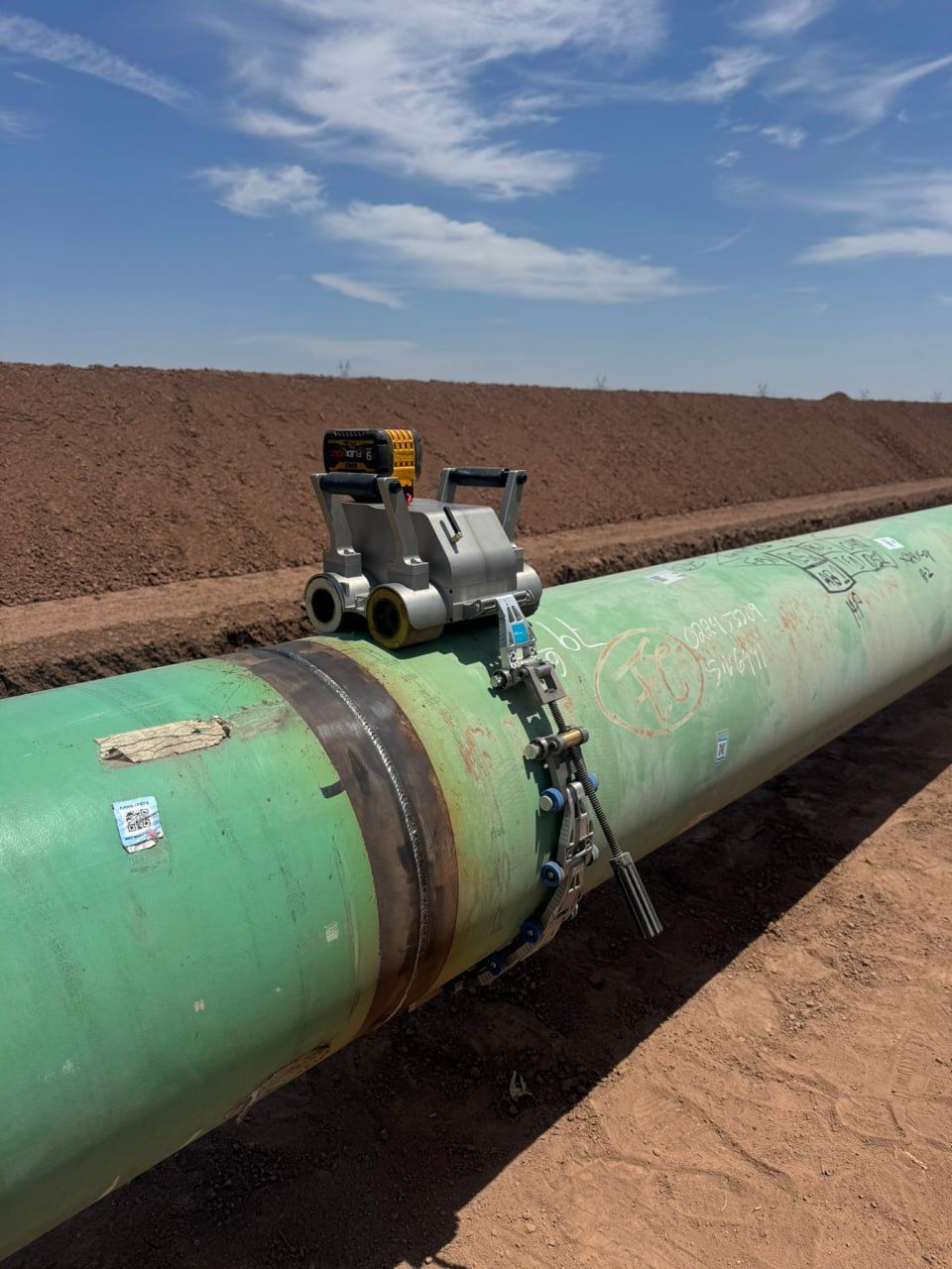 Automated scanner mounted on a coated pipeline girth weld on the right-of-way