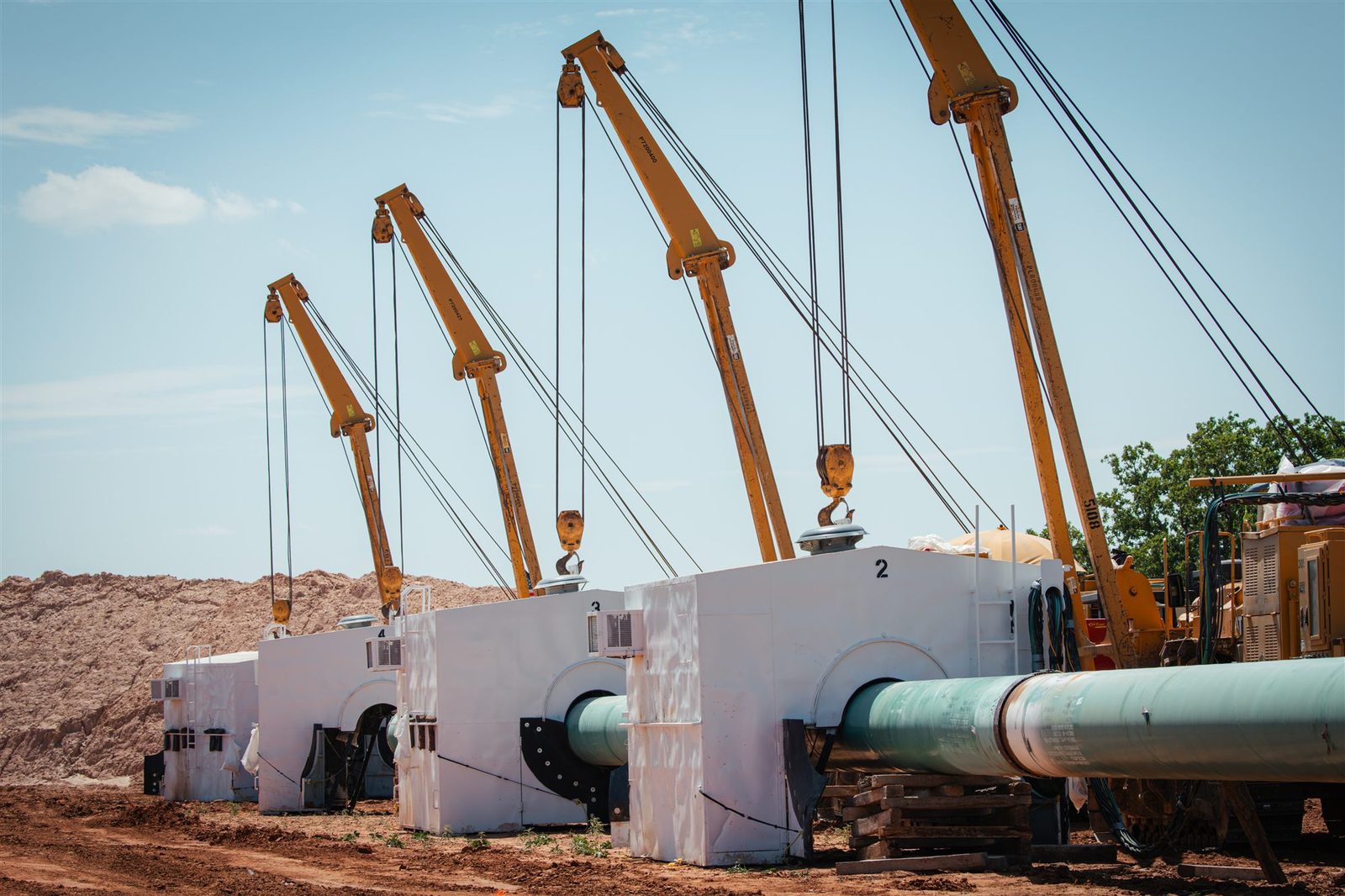 Automated inspection shelter stations staged along a pipeline construction spread